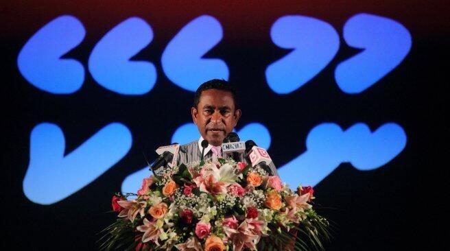 Yameen A Gayoom in front of the backdrop saying 'No!'